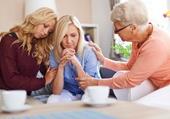 family and friends comforting a troubled woman