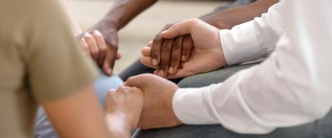close up of racially diverse people holding hands