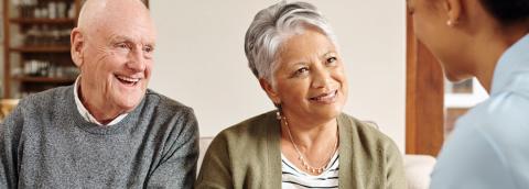Older mixed race couple smiling at therapist