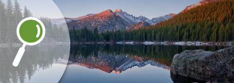 banner of magnifying glass icon over serene mountain lake scene