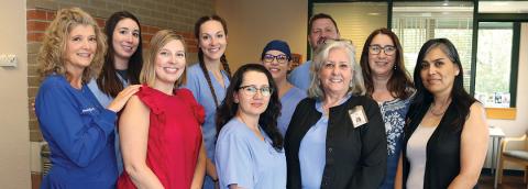 photo of Health District Family Dental Clinic staff standing in clinic lobby with welcoming smiles