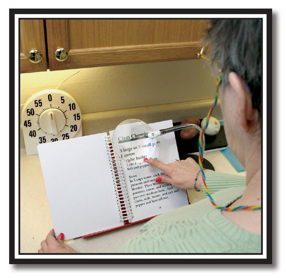 photo of woman in kitchen reading a recipe using a magnifier