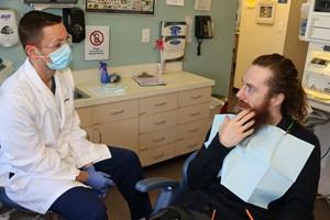Dentist talking with patient in chair