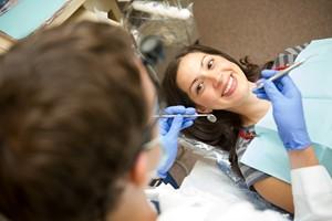 Dental patient in chair looking up at dentist